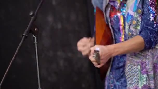 Homme en chemise folklorique joue une balalaika sur une scène lors d'un concert en plein air — Video