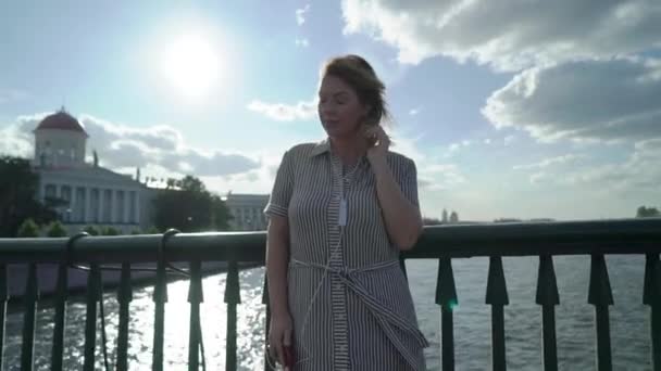 Jeune femme blonde souriante et posant dans une ville — Video