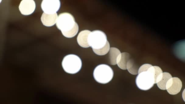 Luzes decorativas de corda ao ar livre penduradas na árvore no jardim à noite — Vídeo de Stock