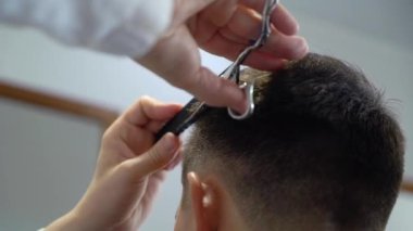 Bir kuaföre tıraş olan bir adam.