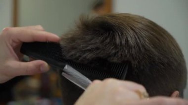Bir kuaföre tıraş olan bir adam.