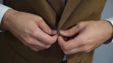 Genç adam üzerinde kahverengi yelek veya ceket closeup koymak