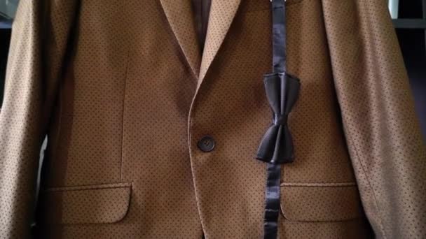 Pajarita estampada azul oscuro sobre fondo chaqueta traje marrón. Feliz día de los Padres o concepto de boda . — Vídeo de stock