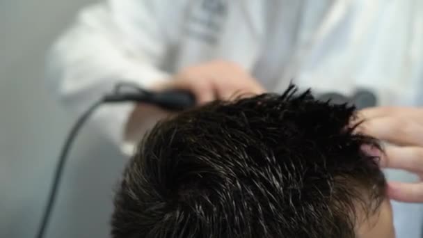 Master stapels haar van mannen haardroger in barbershop, Kapper maakt kapsel voor jonge man. Kapper — Stockvideo