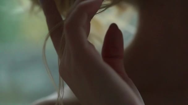 Νεαρή γυναίκα αγγίζει σγουρά ξανθά μαλλιά — Αρχείο Βίντεο