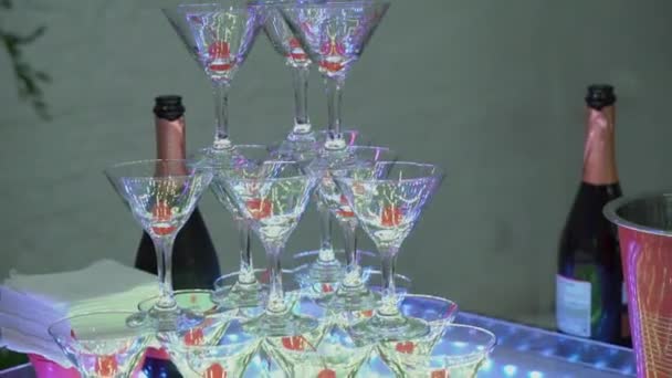 屋内のレストランでパーティーでシャンパン グラスのピラミッド タワー — ストック動画