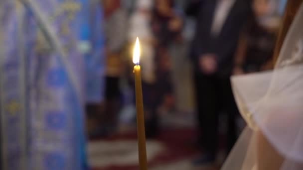 Bruden och brudgummen håller ljus i kyrkan vid ceremoni — Stockvideo