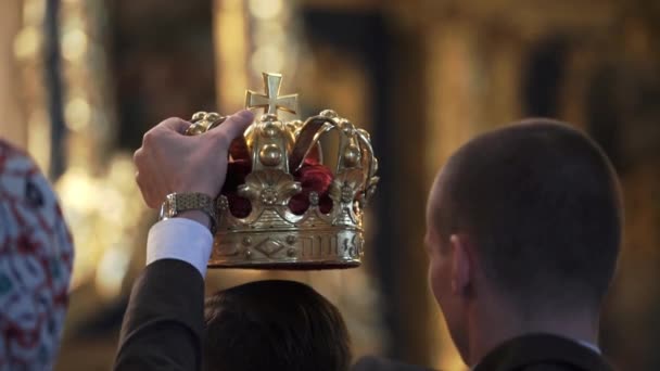 Crowns for wedding in church. Newlyweds at ceremony — Stock Video