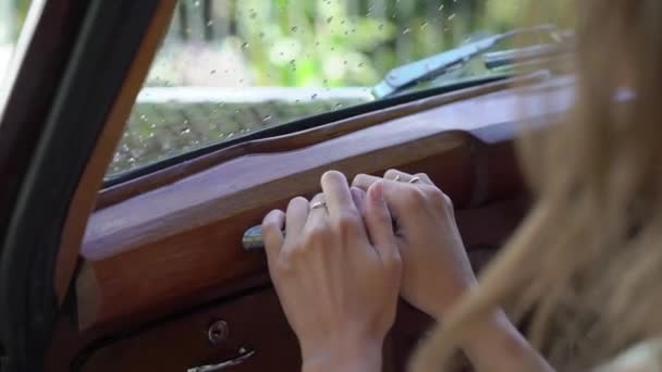 Mujer joven sentada en viejo coche retro — Vídeos de Stock