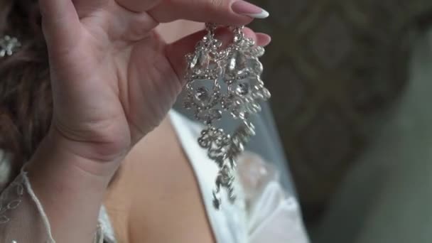若くてきれいな女性のイヤリングを身に着けています。 — ストック動画
