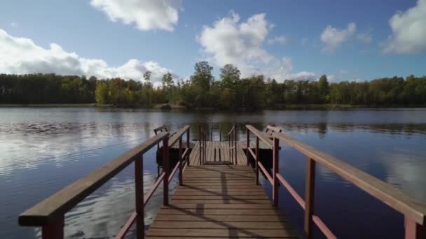 Pier och träbåt vid sjön — Stockvideo