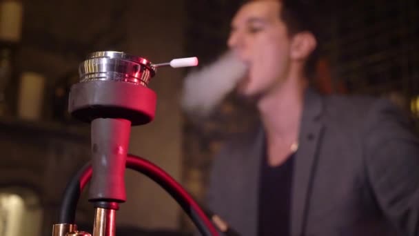 Καπνιστής ναργιλέ. Νεαρός άνδρας shisha καπνίσματος ή ναργιλέ στο καφέ — Αρχείο Βίντεο