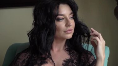 Genç Seksi esmer kadın yatak odasında sandalye üzerinde oturan ve poz iç çamaşırı.