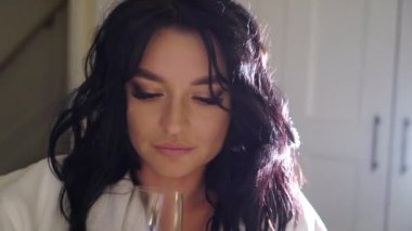 Genç seksi çift gece yatak odasında beyaz bornoz Gözlük şampanya içmek döşeme. Genç kadın ve adam romantik tarihi. Daha önce seks alkollü içecekler.