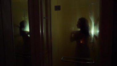 Genç güçlü seksi kadın alarak duş çıplak. Siluet slowmotion