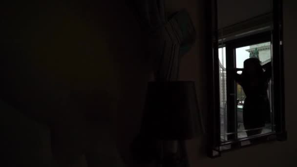 Ung sexet brunette kvinde i undertøj opholder sig i soveværelset nær vinduet og poserer . – Stock-video