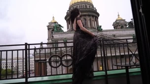 Balkon bir şehirde kalan siyah lüks içinde genç seksi esmer kadın — Stok video