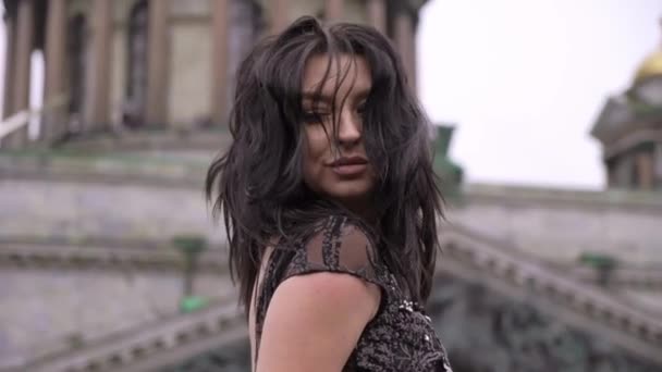 Jeune femme brune sexy en robe de luxe noire séjournant au balcon dans une ville — Video