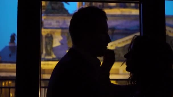 若いセクシーなカップルを受け入れ、窓の近くの夜のシルエットにキス — ストック動画