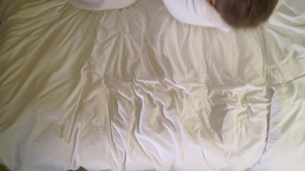 Junge sexy Paar in der Nacht im Schlafzimmer in weißen Bademänteln liegen und Spaß haben. Lächeln und Lachen — Stockvideo