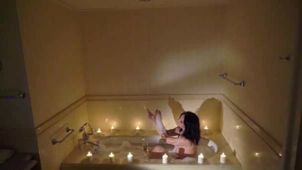 Joven morena sexy yendo al baño, desnudándose quitando el albornoz y acostándose en el tubo de baño . — Vídeos de Stock
