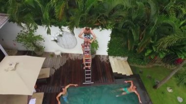 Bali, Endonezya - 8 Kasım 2017: İnsanlar kuleden havuza atlamak. Tropikal Villa parti yaz aylarında. Tatil