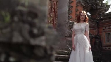 Budist Tapınağı Bali yakınındaki poz güzel gelin. Tarafından yakın yürüme, peçe sallayarak. Romantik düğün. Tatil tropikal.