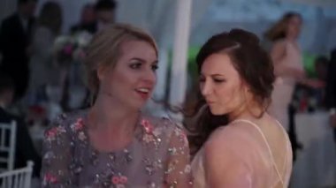 İki genç kız partide dans. Abiye Event'de arkadaşlar: düğün, Doğum günü veya tatil.