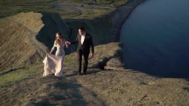 Gelin ve damat günbatımında dağda yürüyüş