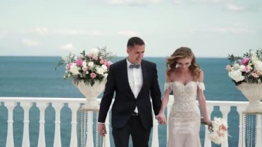 Gelin ve damat düğün töreninde. Aşık gül yaprakları atma konuklar ile genç bir çift. Denizin kenarında düğün