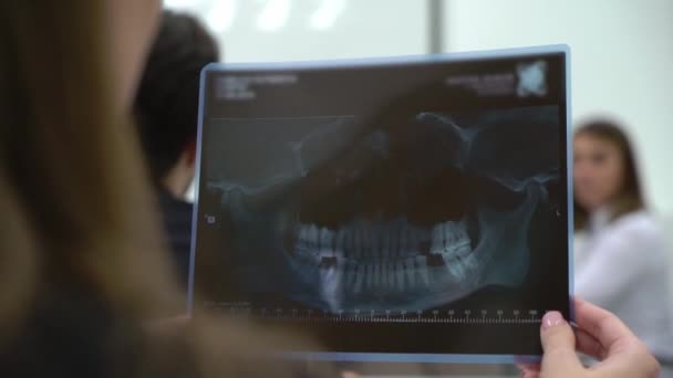 Medical student doctor holding X-ray film of teeth and jaw. — Stock Video