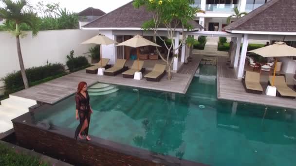Young sexy woman in black lingerie walking near pool at luxury villa — Stock Video