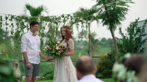 Sposo e sposo alla cerimonia nuziale. Giardino tropicale la sera. Bella coppia di sposi novelli — Video Stock
