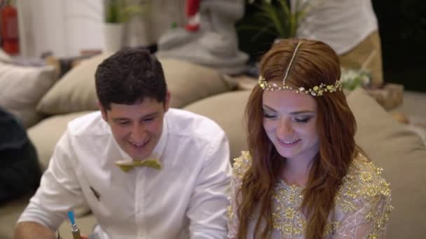 Una giovane ragazza e un uomo che guardano un video a una festa su un computer portatile o tablet . — Video Stock