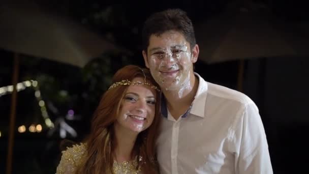 Fille enduit un morceau de gâteau de mariage sur le visage du marié. La célébration du mariage .