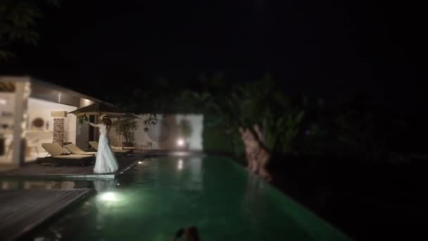A noiva joga um buquê no casamento. Festa na piscina à noite — Vídeo de Stock