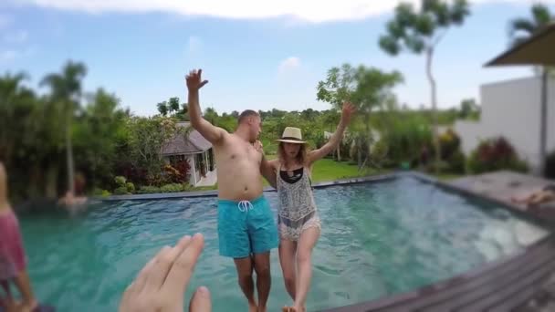 Young lovely couple photographed and fall into swimming pool at tropical vacation villa. — Stock Video