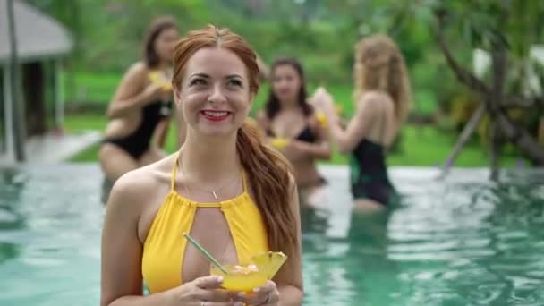 Pacar di kolam renang. Pesta di liburan musim panas. Gadis dentingan gelas dengan koktail alkohol — Stok Video