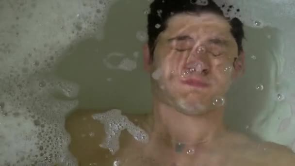 A young man takes a bath. Dives and emerges. Suicide attempt — Stock Video