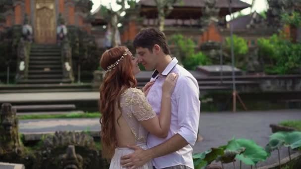 신혼 부부 발리에서 불교 사원 근처 포즈입니다. 손을 잡고, 포옹입니다. 로맨틱 한 결혼식. — 비디오