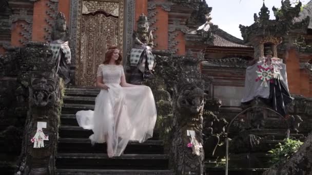 Красива наречена позують поблизу буддійський храм на острові Балі. Ходьба поблизу. Романтичне весілля. — стокове відео