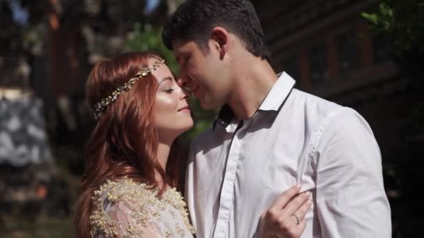 新婚夫婦はバリ島の寺院の近くのポーズします 手をハグします ロマンチックな結婚式 熱帯の休暇 — ストック動画
