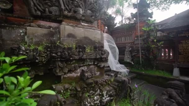 Krásná nevěsta lodě poblíž buddhistický chrám ve městě Bali. Chůze v blízkosti. Romantická svatba. — Stock video