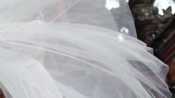 バリの寺院に近いポーズ美しい花嫁。近くを歩いてください。ロマンチックな結婚式. — ストック動画