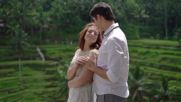 Newlyweds posing at rice terrace in Bali. Holding hands, hugging. Romantic wedding. — Stock Video