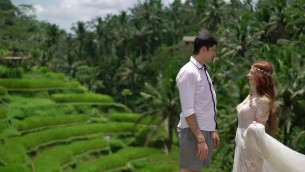 新婚夫婦はバリ島のライステラスのポーズします。手をハグします。ロマンチックな結婚式. — ストック動画