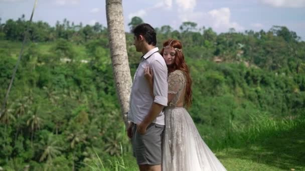 Cliff Bali yakınındaki poz yeni evliler. Tutan eller, sarılma. Romantik düğün. — Stok video