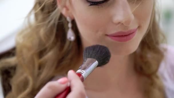 Επαγγελματική makeup artist που εργάζονται με όμορφη νεαρή γυναίκα — Αρχείο Βίντεο