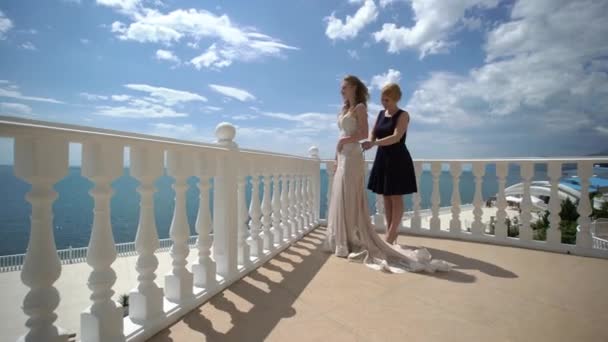 Bruidsmeisje lace dress bruid op het terras. Bruiloft aan zee. — Stockvideo