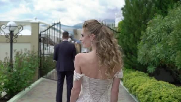 Mladá krásná nevěsta ve svatebních šatech jde ženich. Setkání novomanželů. — Stock video